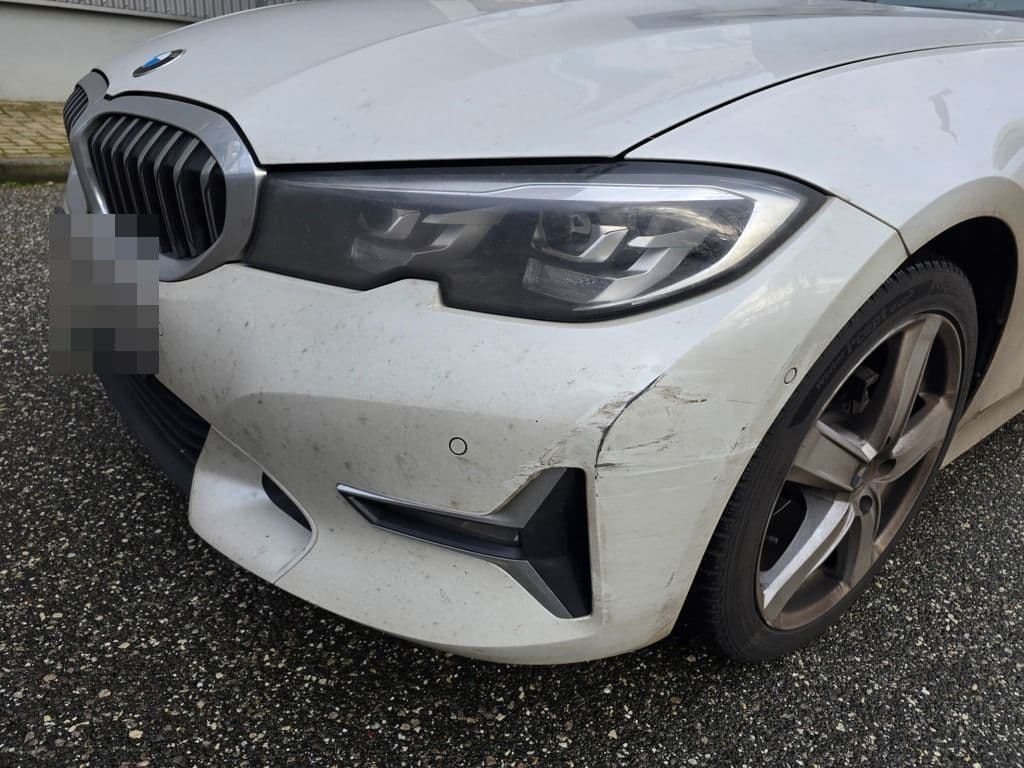 BMW mit beschädigter Frontschürze und Nebelscheinwerfer