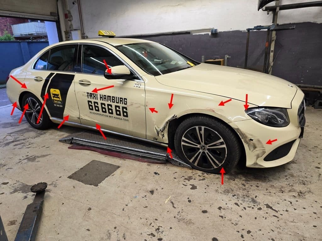 Taxi in der Halle, sämtliche Anstoßstellen mit roten Pfeilen markiert