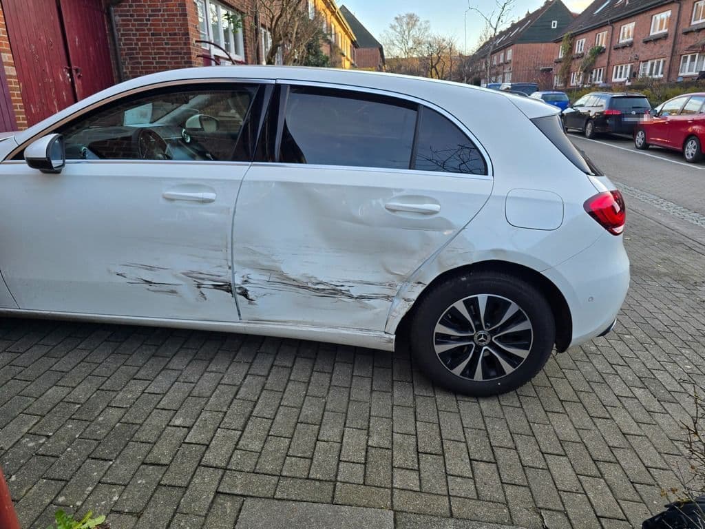 Weiße Mercedes A-Klasse mit durchgehendem Streifschaden über beide Türen